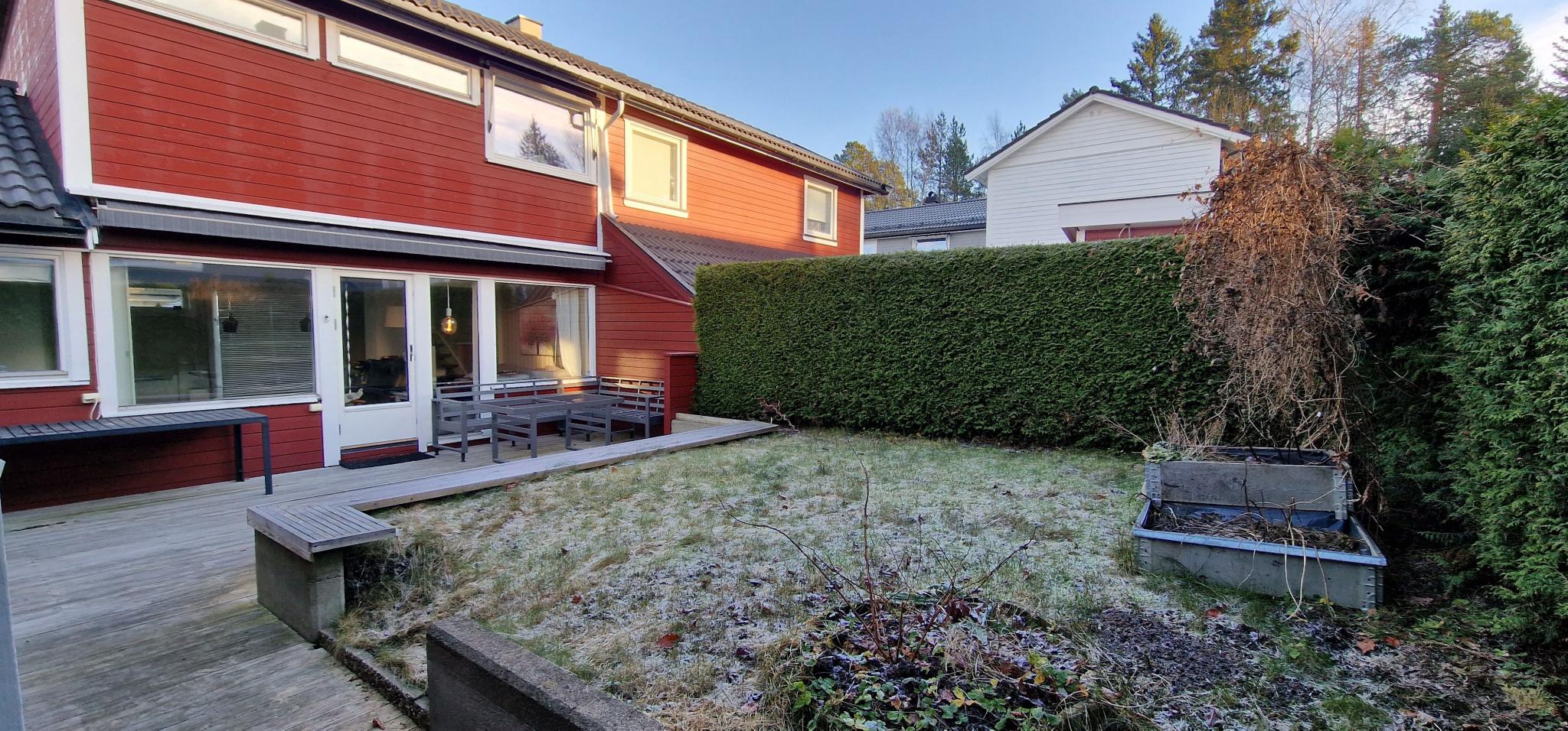 Bakside hage. Med stor platting og sittegruppe og elektrisk markise